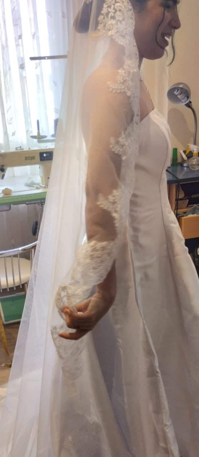 Arreglar vestido de novia en barrio Salamanca 4 Modista vestidos de novia ajustando el bajo con cola en el taller de Villanueva